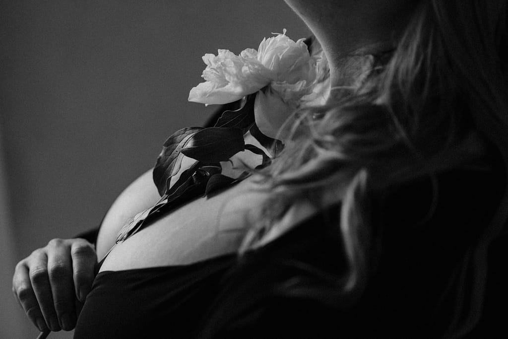 Vancouver plus size inclusive boudoir photoshoot portrait of a woman with a flower in her had by her breast