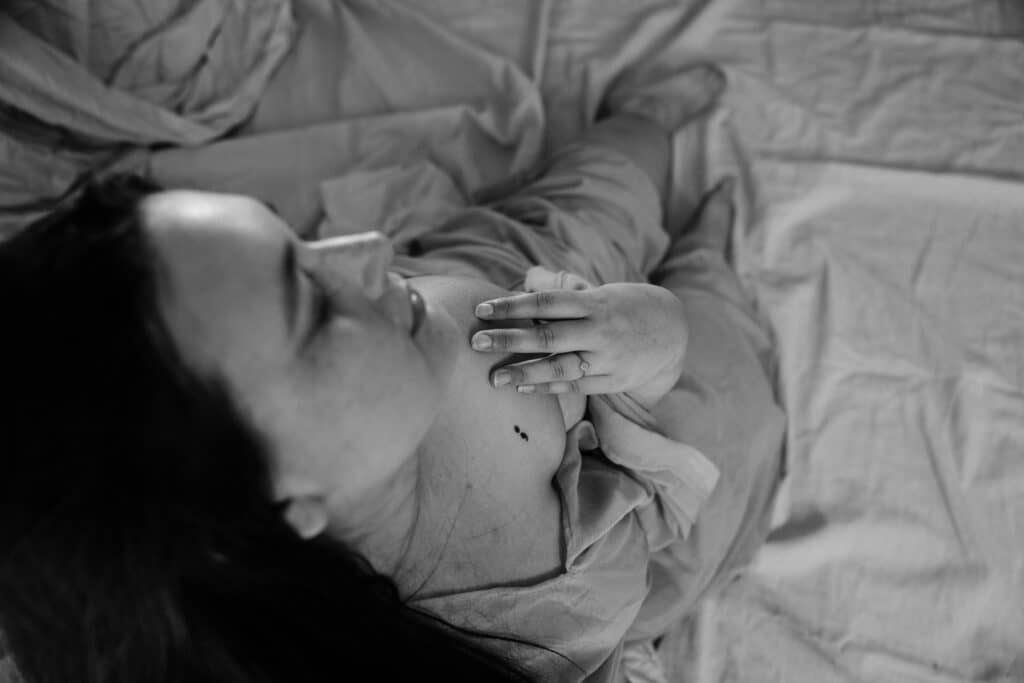 feminine embodiment boudoir image of woman taken from above looking down on decolletage showing tattoo on chest