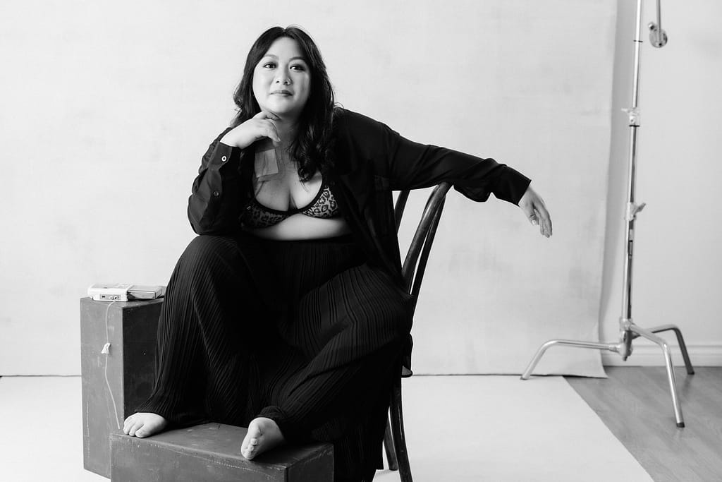 black and white photo showing diversity with a woman sitting on a chair wearing a black outfit and medical equipment