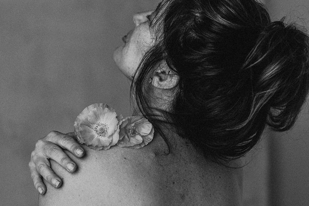 Vancouver Boudoir Photographer Michele Mateus creates portraits of women embodying their feminine energy. PIctured here is a woman connecting with a flower in a meditative moment.