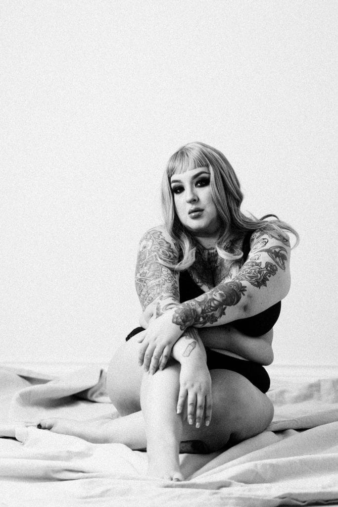 black and white empowerment photography image of a woman sitting on the floor in lingerie