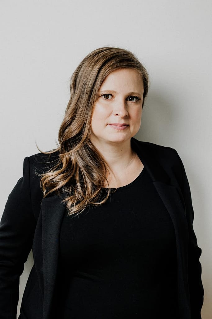 headshot of woman wearing black suit