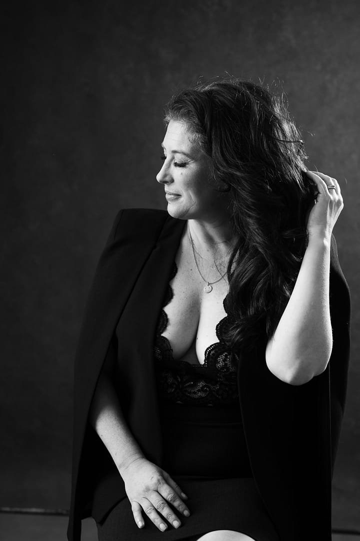 vancouver boudoir image of woman wearing plunging top revealing cleavage and hand at hair