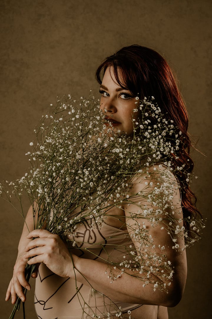 Plus size boudoir photo of a woman holding baby's breath
