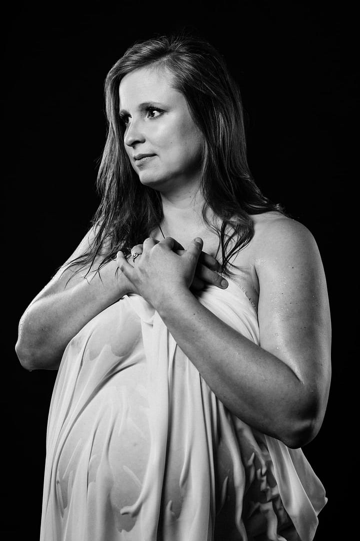 Vancouver-Maternity-Boudoir woman holding a wet sheet draped over her pregnant belly