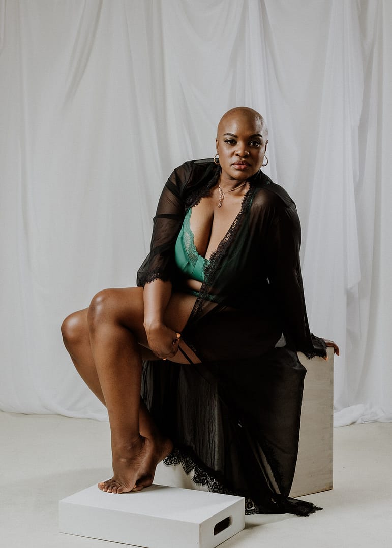 vancouver boudoir photographer image of plus size black woman with alopecia wearing lingerie and sitting on a block