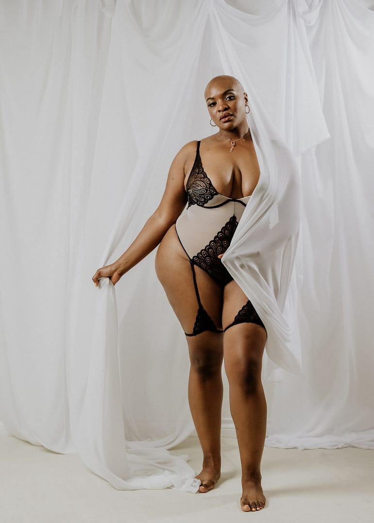 vancouver boudoir photographer image of plus size black woman with alopecia wearing lingerie and draped in white fabric
