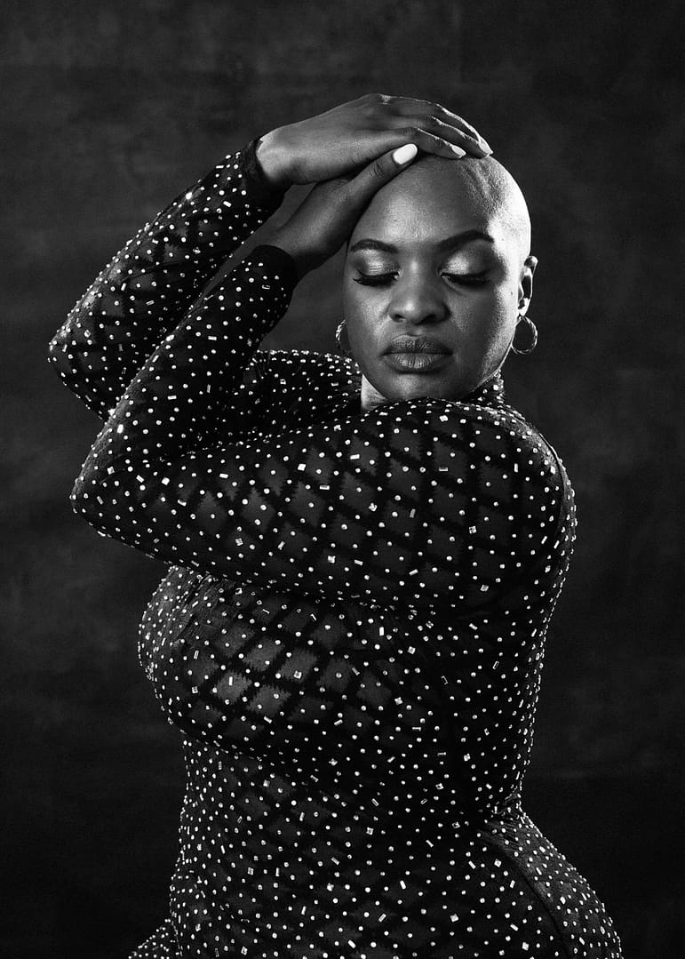 vancouver boudoir photographer image of plus size black woman with alopecia in glitter dress and hands resting on naked head