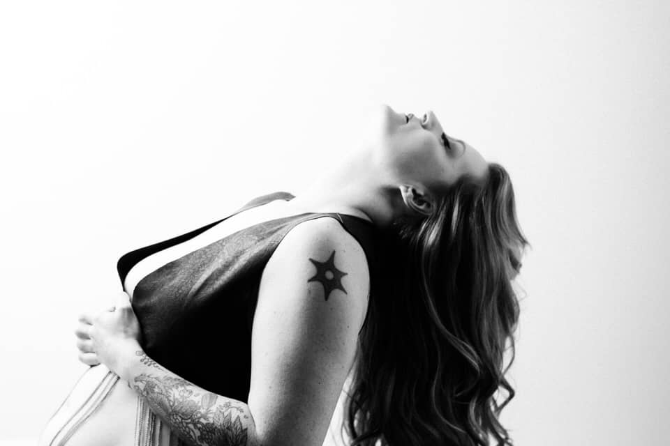 black and white boudoir image of a woman leaning back letting her hair fall
