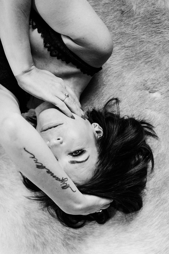 Black and white portrait of a woman with arm tattoo. Vancouver boudoir portrait studio.