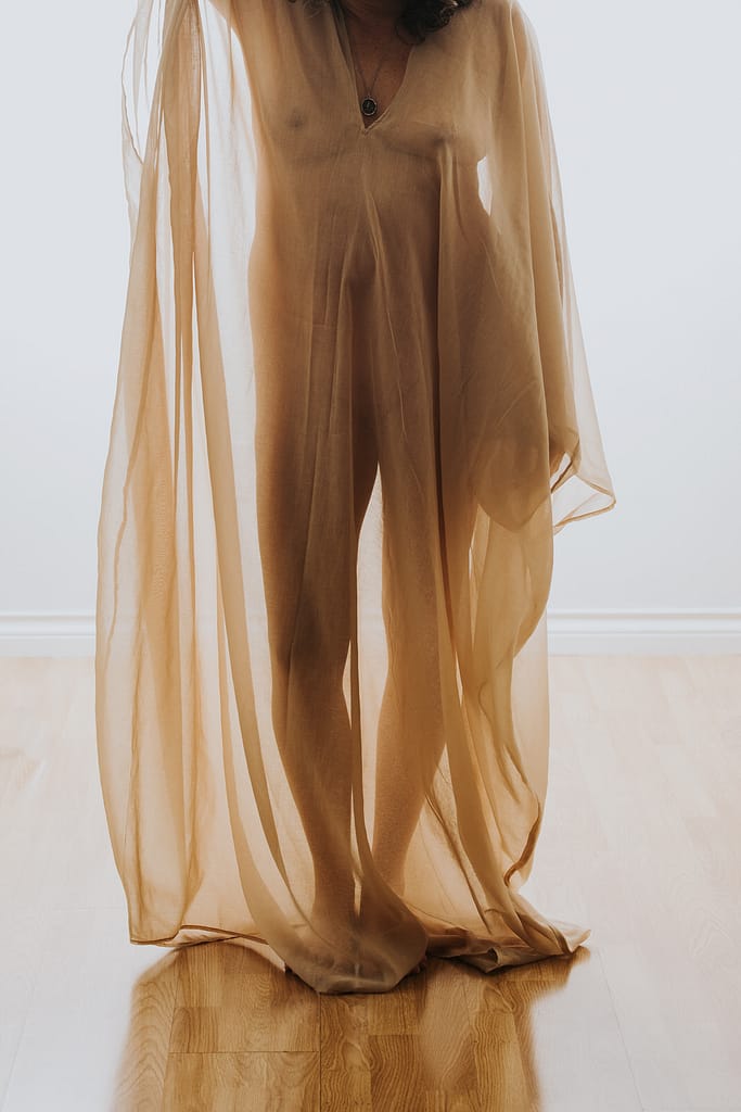 boudoir image of woman changing the ageing narrative wearing a sheer robe and wearing nothing underneath 