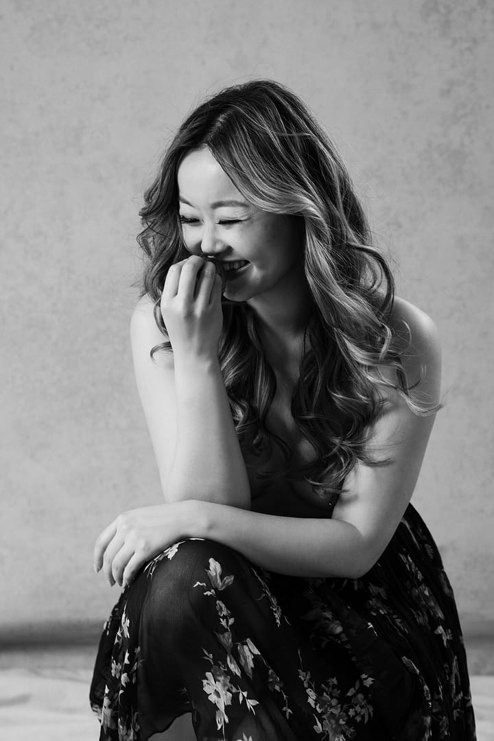 Black and white boudoir image of a woman laughing, Vancouver Boudoir Studio Mateus Studios