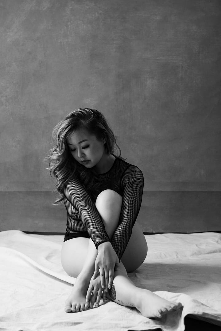 Timeless Black and white boudoir photo of a woman sitting on studio floor, Vancouver Boudoir Studio Mateus Studios